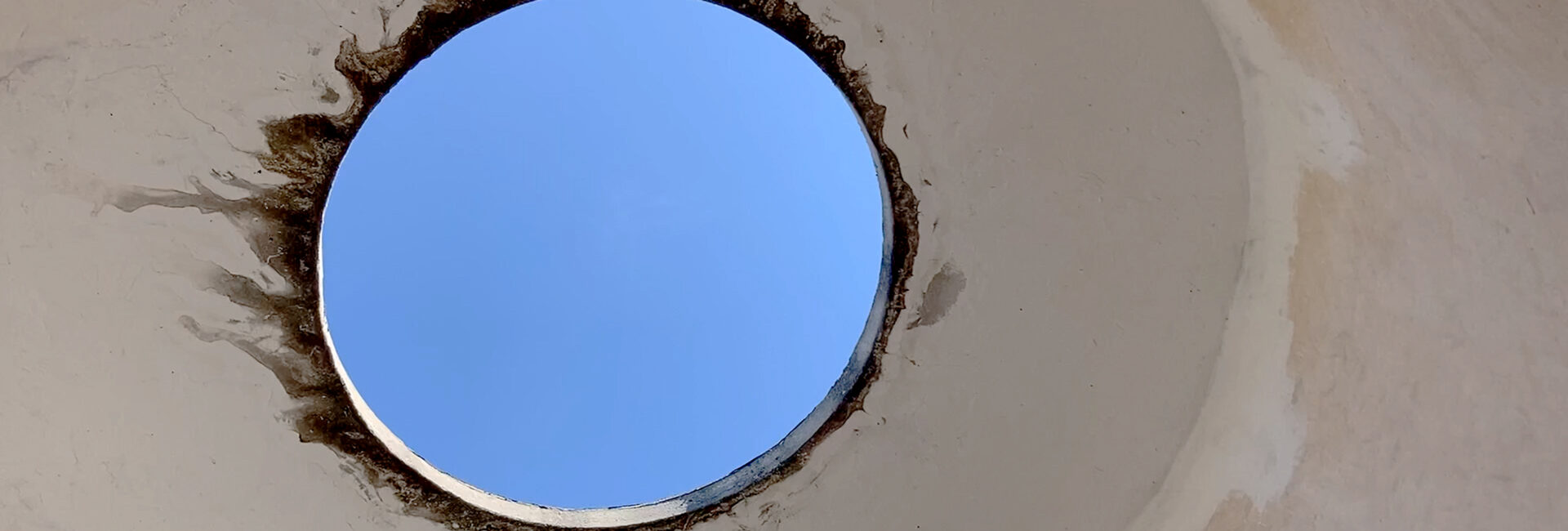 A circular white wall with a hole in it