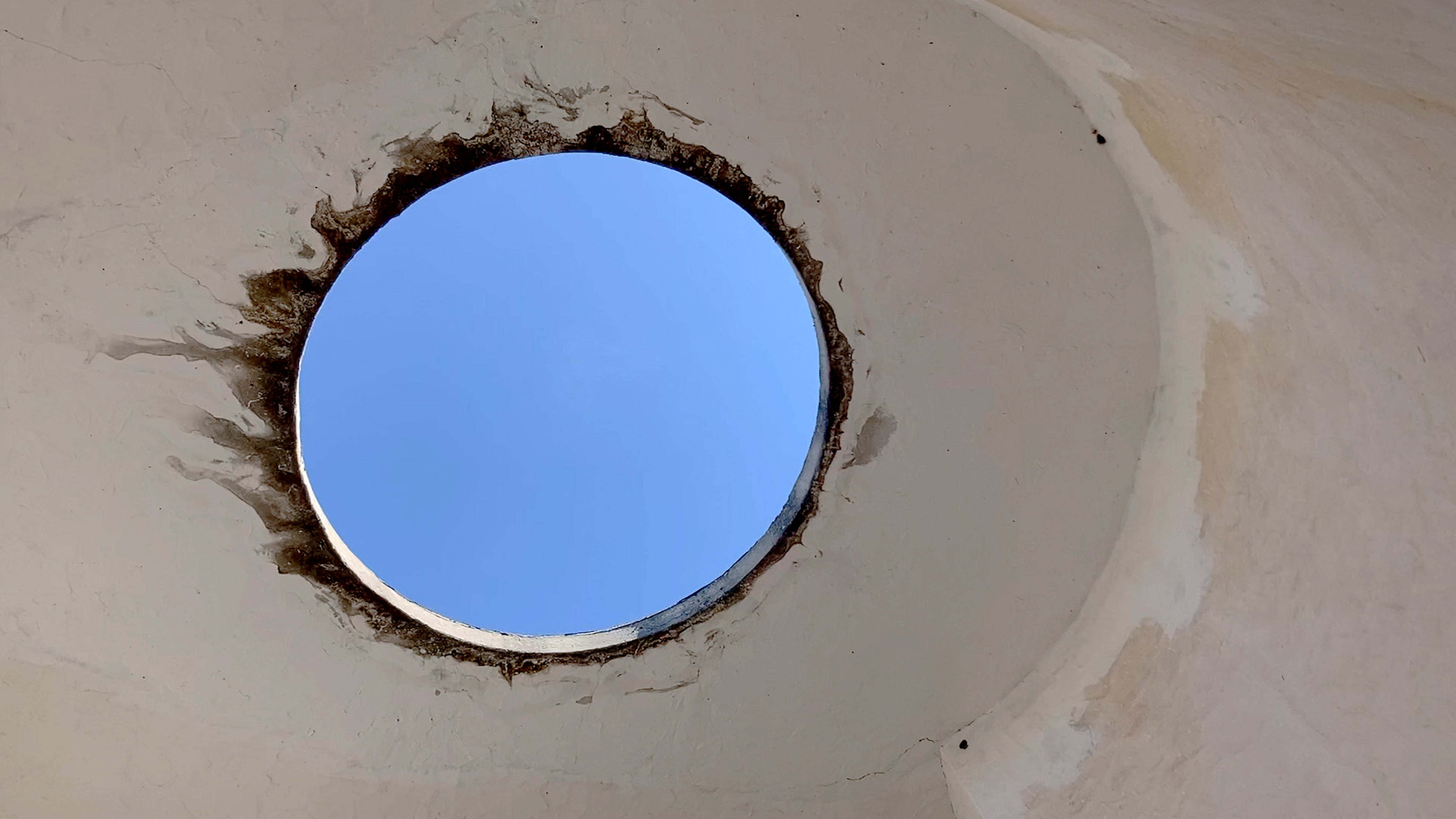 A circular white wall with a hole in it